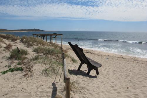 Great spot for surfing with wooden shelter and seat sitting in the sand