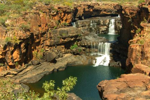 water cascading over vast granite rock cliffs in the Kimberley outback at Mitchell Falls