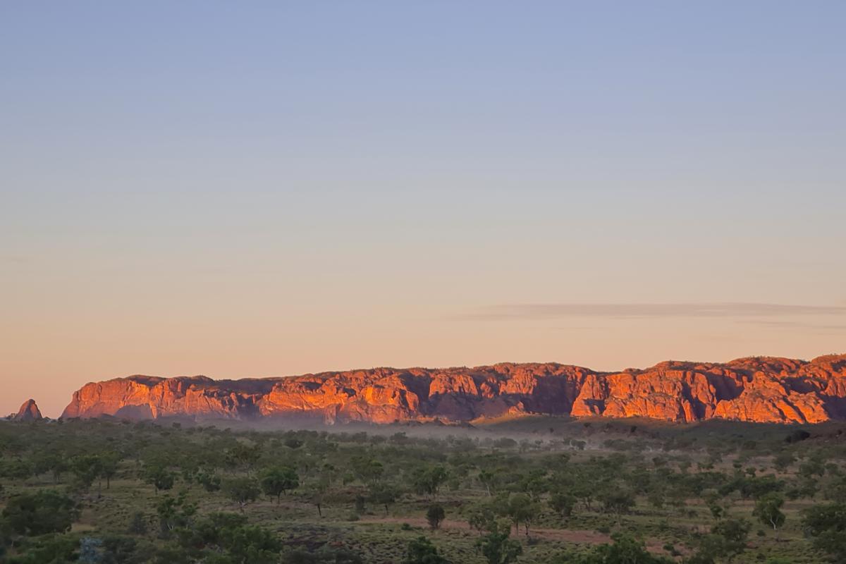 Sunset views from Kungkalanayi Lookout to the Bungle bungle Ranges with soft mist moving across the landscape.