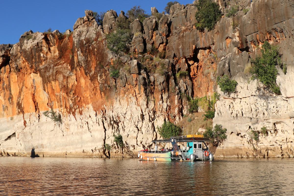 tour boat on the river in danggu geikie gorge with towering gorge walls