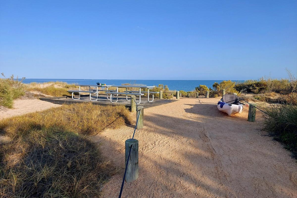 Beach access path and communal picnic tables at Yardie Creek Campground